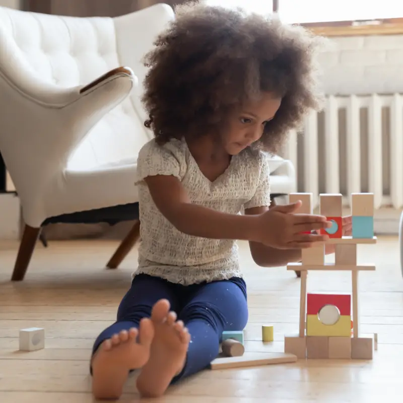 une jeune fille qui construit avec des blocs