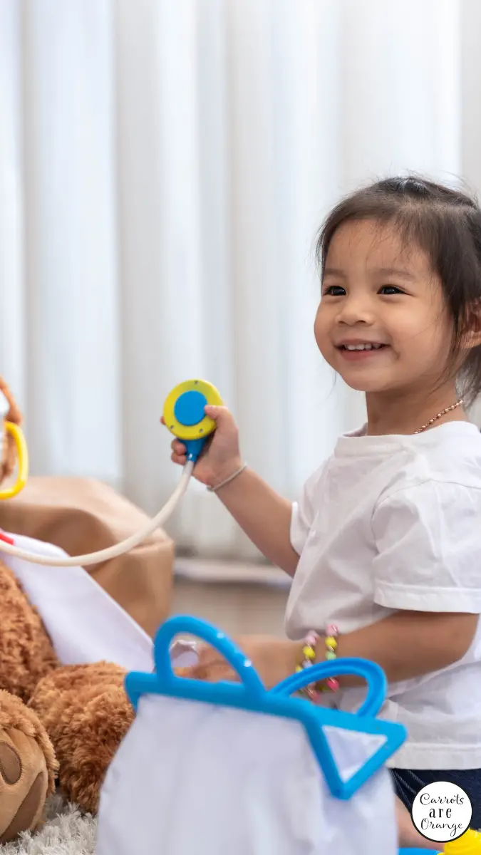 une jeune fille asiatique souriante fait semblant de jouer au docteur