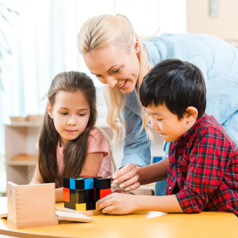 un guide Montessori travaillant avec le cube binomial en classe avec des enfants