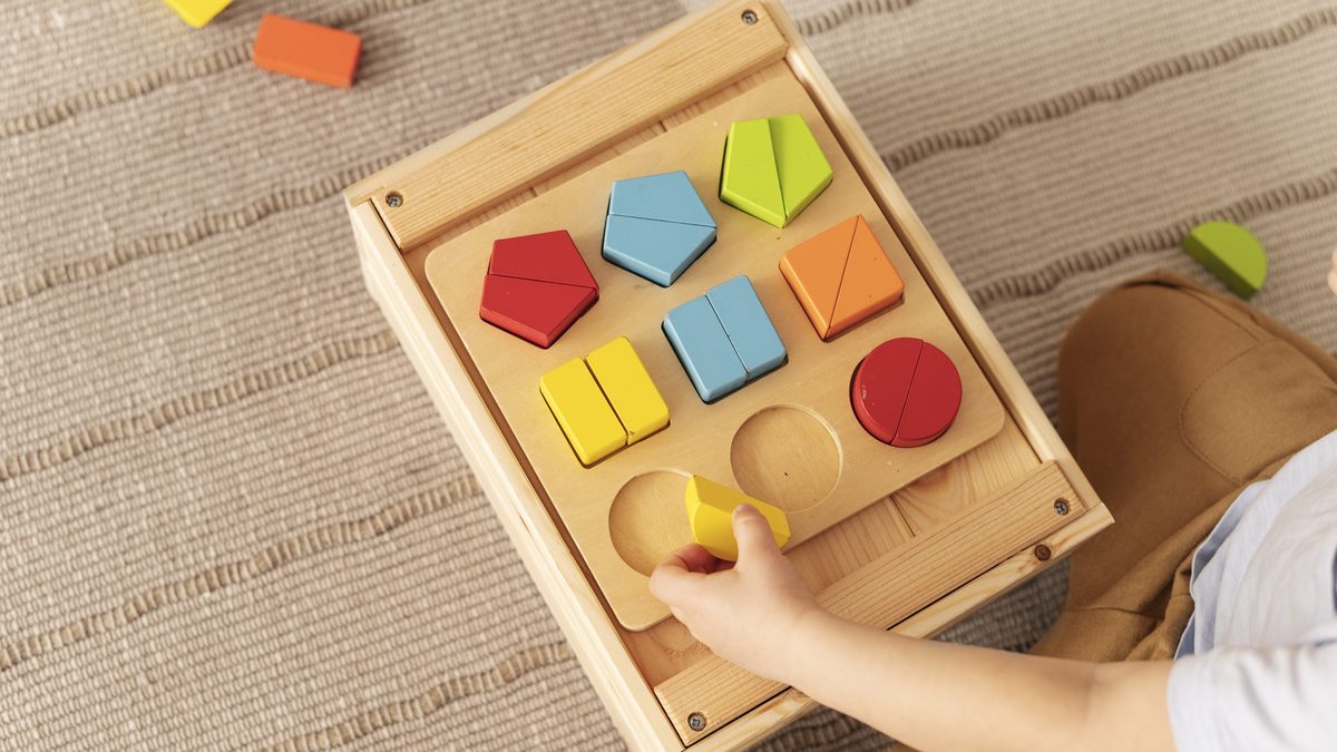 Enfant manipulant du matériel sensoriel en bois